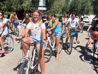 Gruppo di ragazzi in bicicletta sotto il sole, giornata estiva.