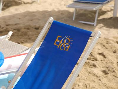 Chaise longue bleue avec logo Elea sur la plage.