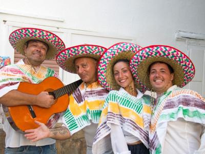 Groupe en tenues mexicaines traditionnelles avec sombreros colorés et guitare.