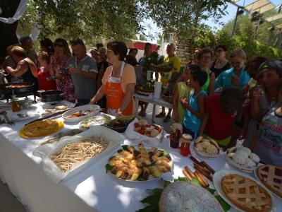 Festa all'aperto con cibo tradizionale e persone riunite.