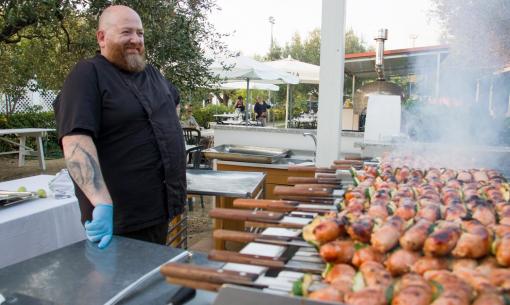 Chef prepara spiedini alla griglia all'aperto.