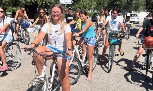 Gruppo di ragazzi in bicicletta sotto il sole, giornata estiva.