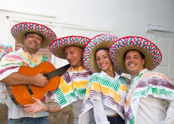 Groupe en tenues mexicaines traditionnelles avec sombreros colorés et guitare.