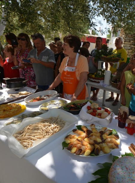 Dimostrazione culinaria all'aperto con piatti tradizionali e pubblico curioso.