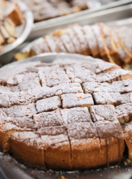 Torta a fette con zucchero a velo su un vassoio.