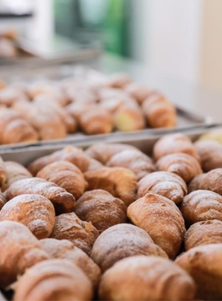 Deliziosi croissant appena sfornati, spolverati con zucchero a velo, pronti da gustare.