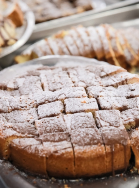 Torta a fette, spolverata di zucchero a velo, su un vassoio.