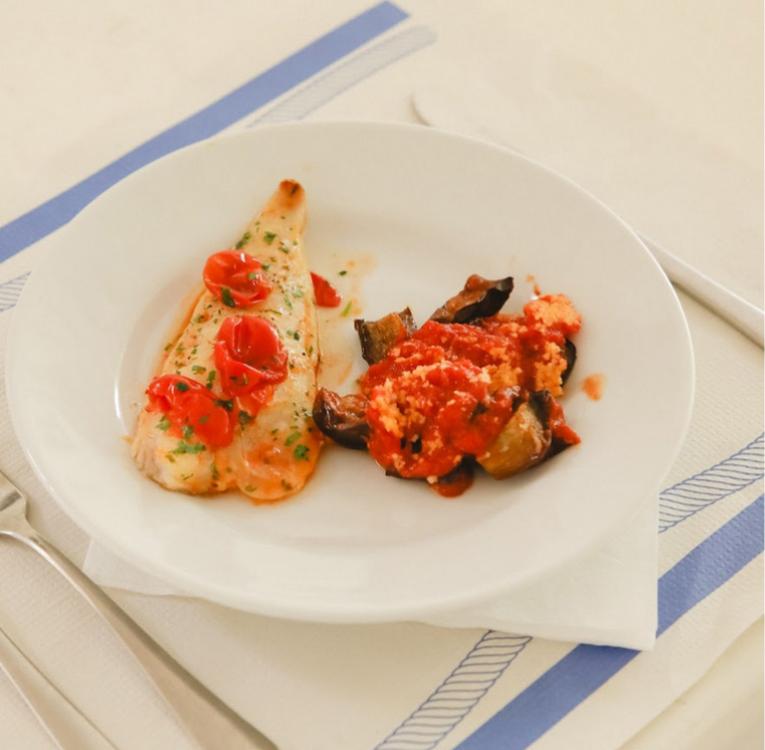 Filetto di pesce con pomodorini e contorno di melanzane al pomodoro.