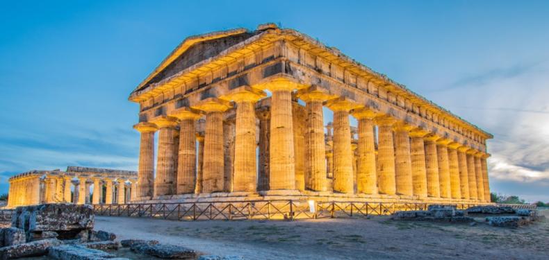 Tempio greco antico illuminato al tramonto, con colonne doriche imponenti e maestose.